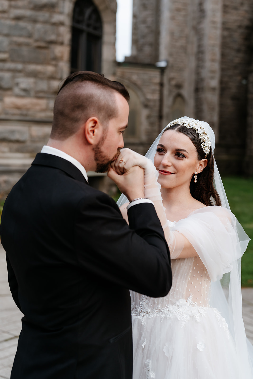 groom kissing the bride's hand for a romantic wedding portrait