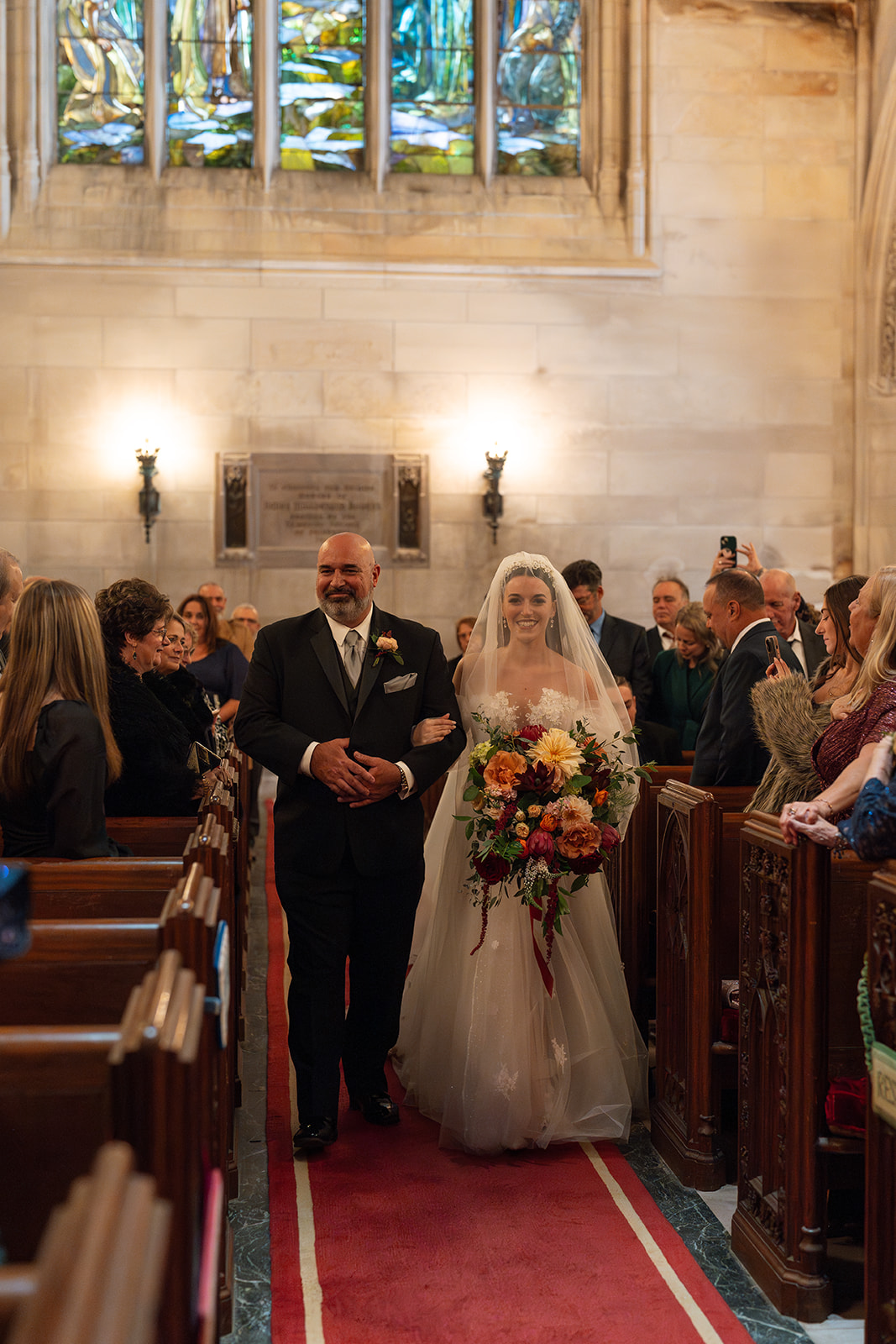 bride walking down the aisle with her father in a church