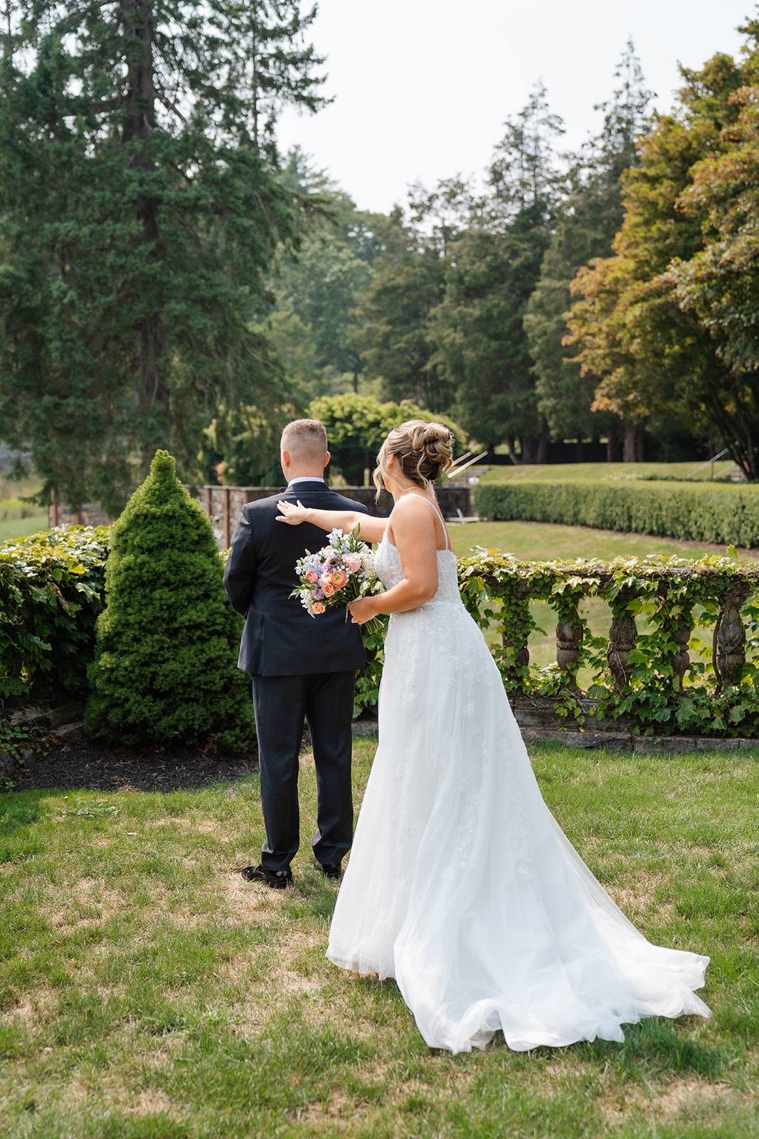 bride tapping shoulder of groom during first look