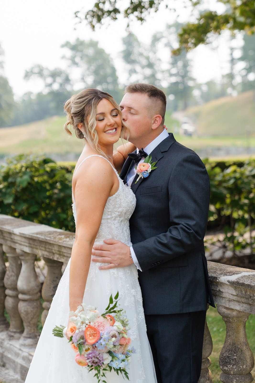 groom kisses bride's cheek for a romantic wedding photo