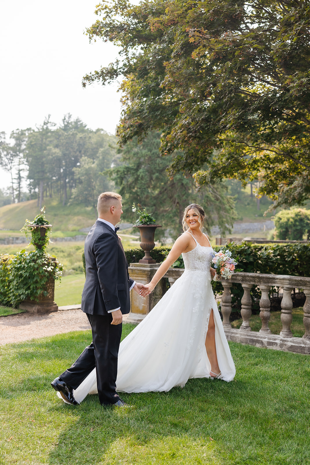 bride and groom holding hands in a garden at the Mansion on Turner Hill Wedding Venue