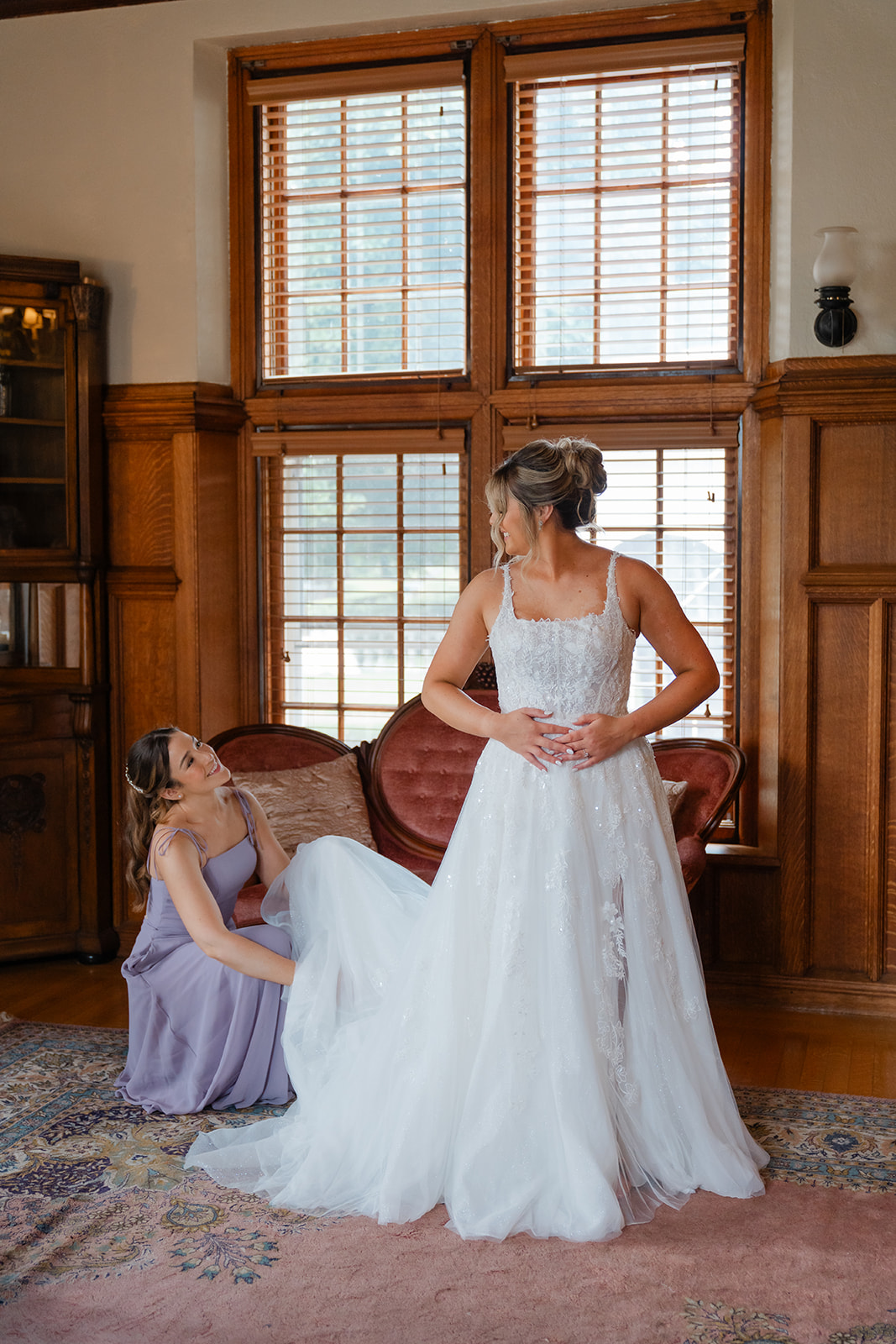 bridesmaid helping the bride as they get ready