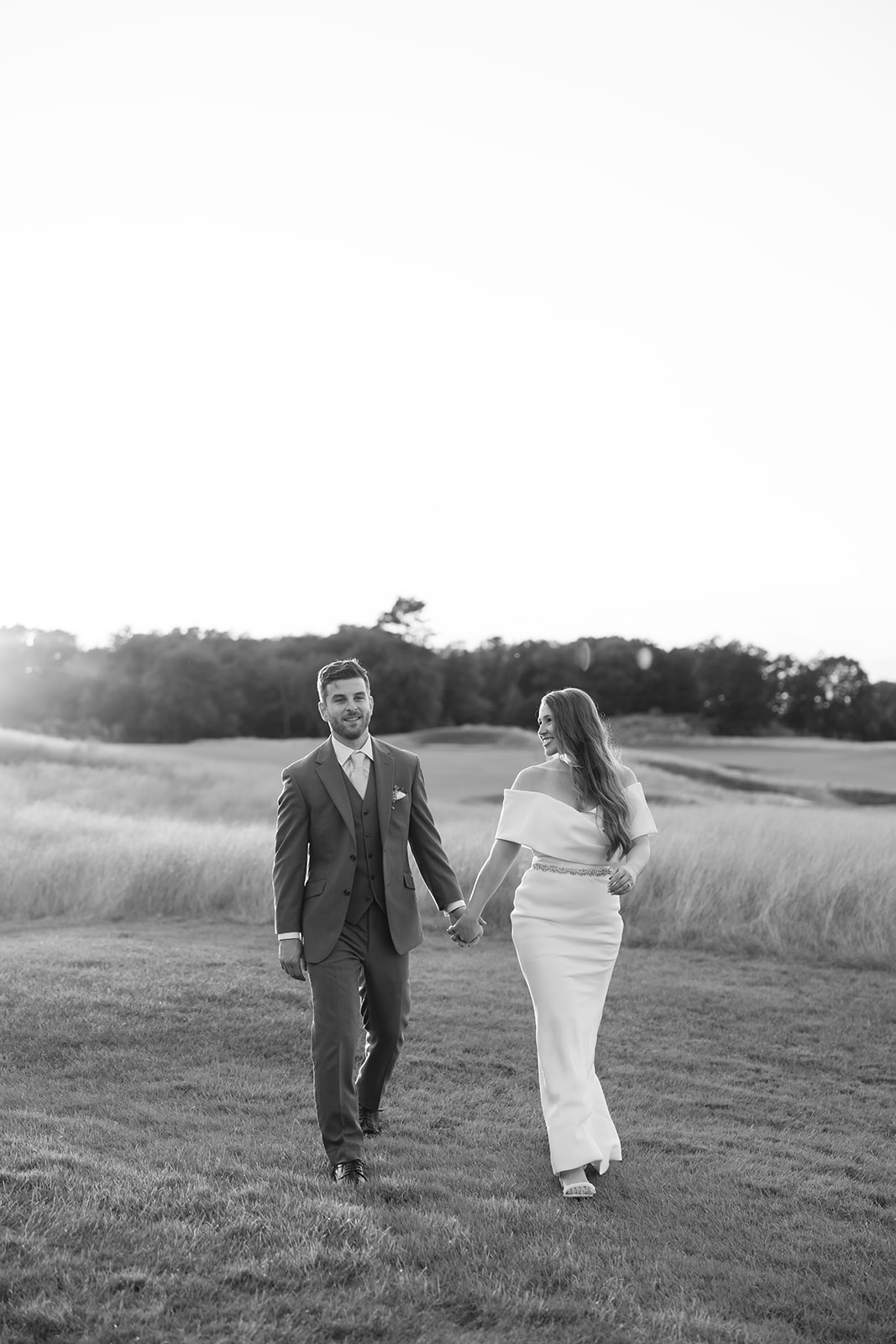 wedding couple holding hands in a field 