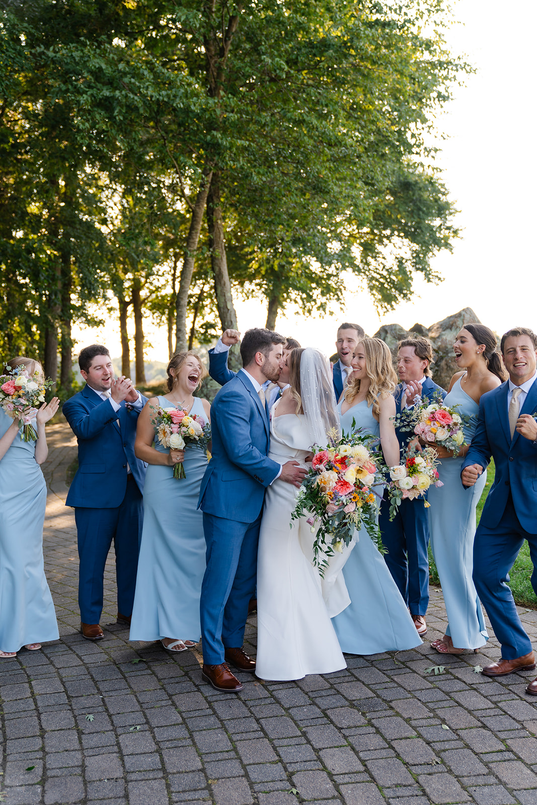 groom and bride kisses during bridal party photo