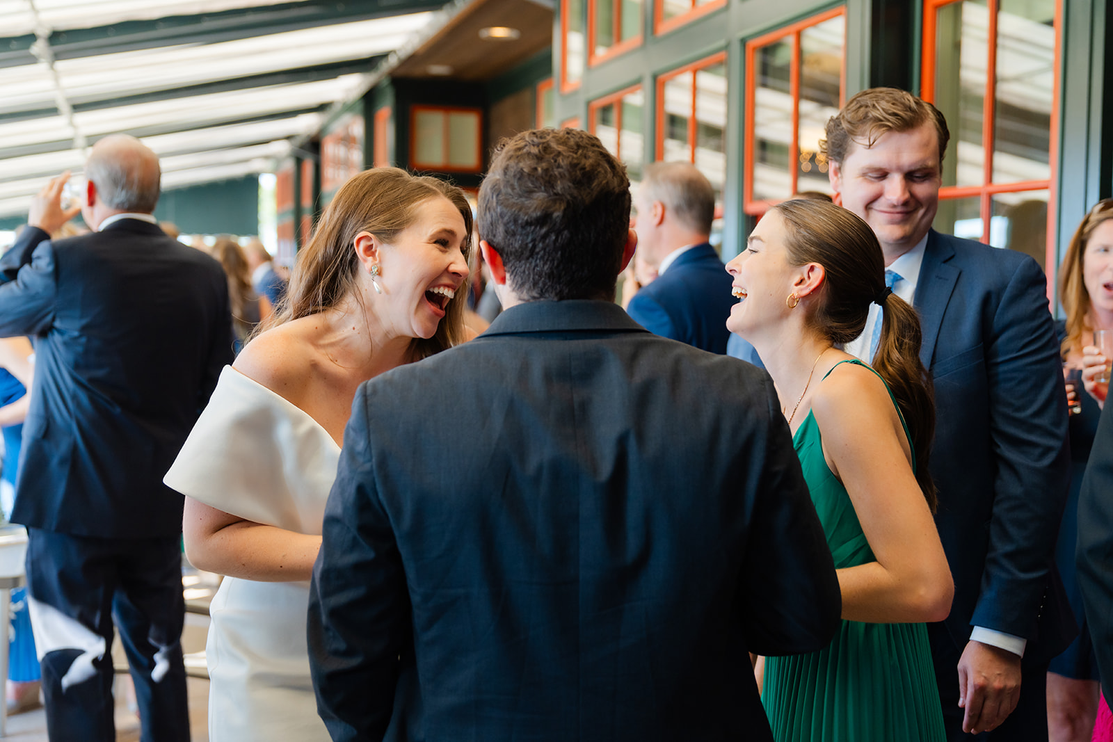 candid photo of the bride laughing with guest during cocktail hour