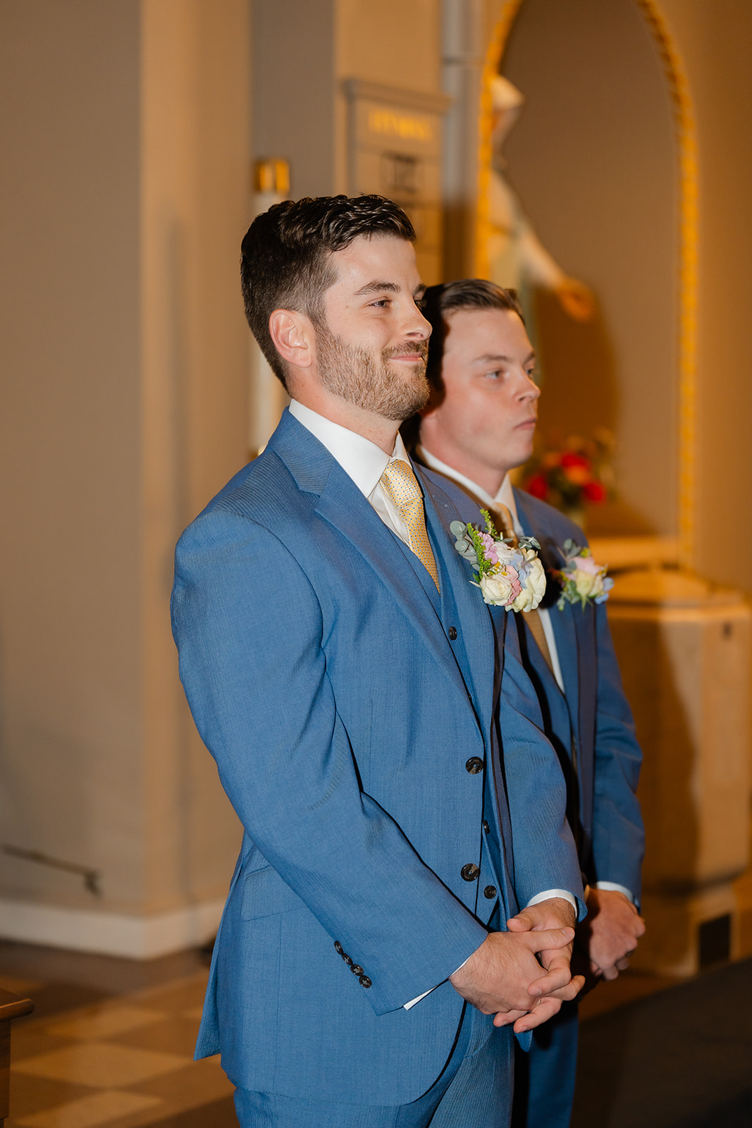 groom smiling as the bride walks down the aisle