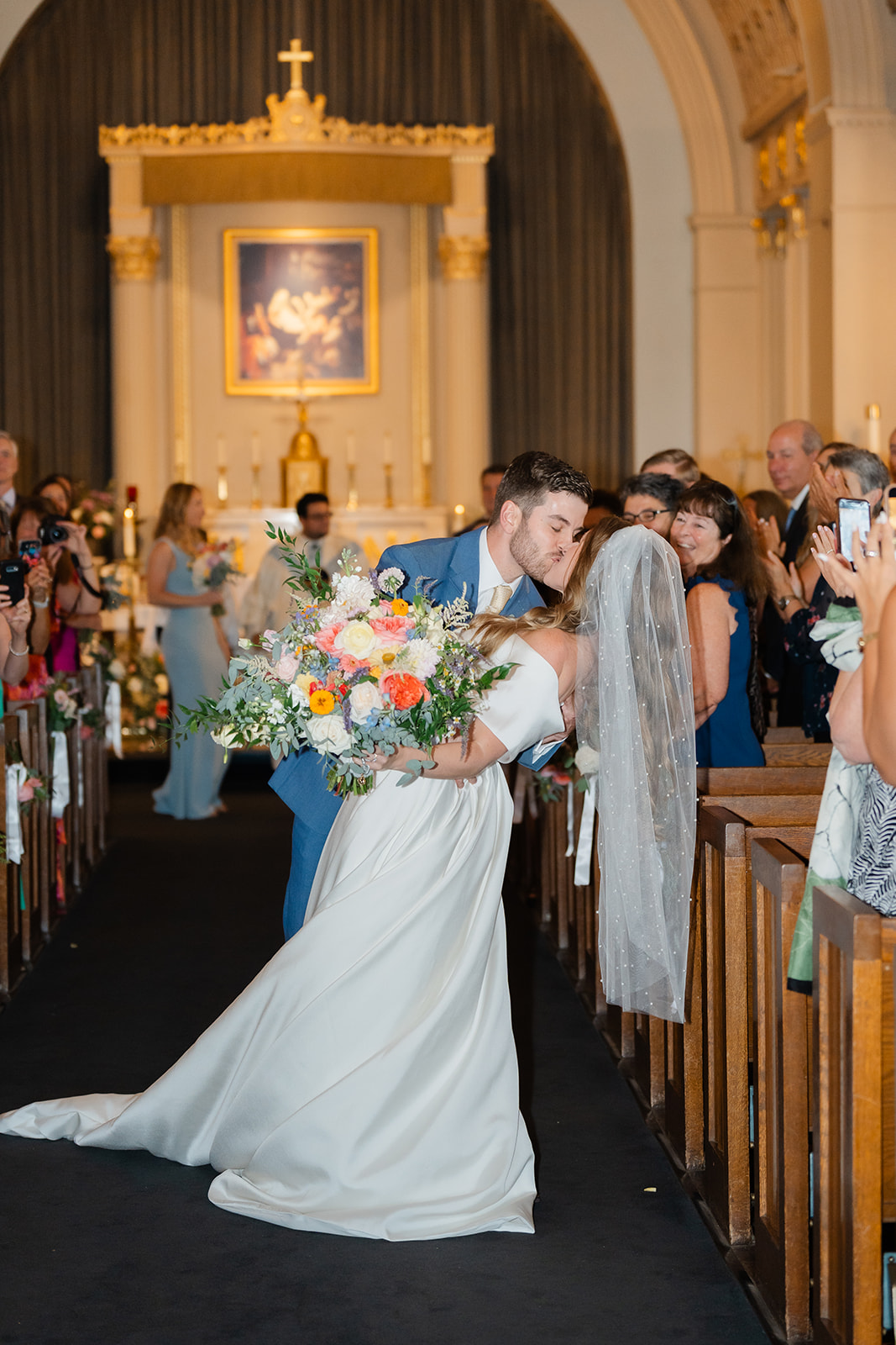 candid wedding photo during wedding ceremony as the bride and groom kiss