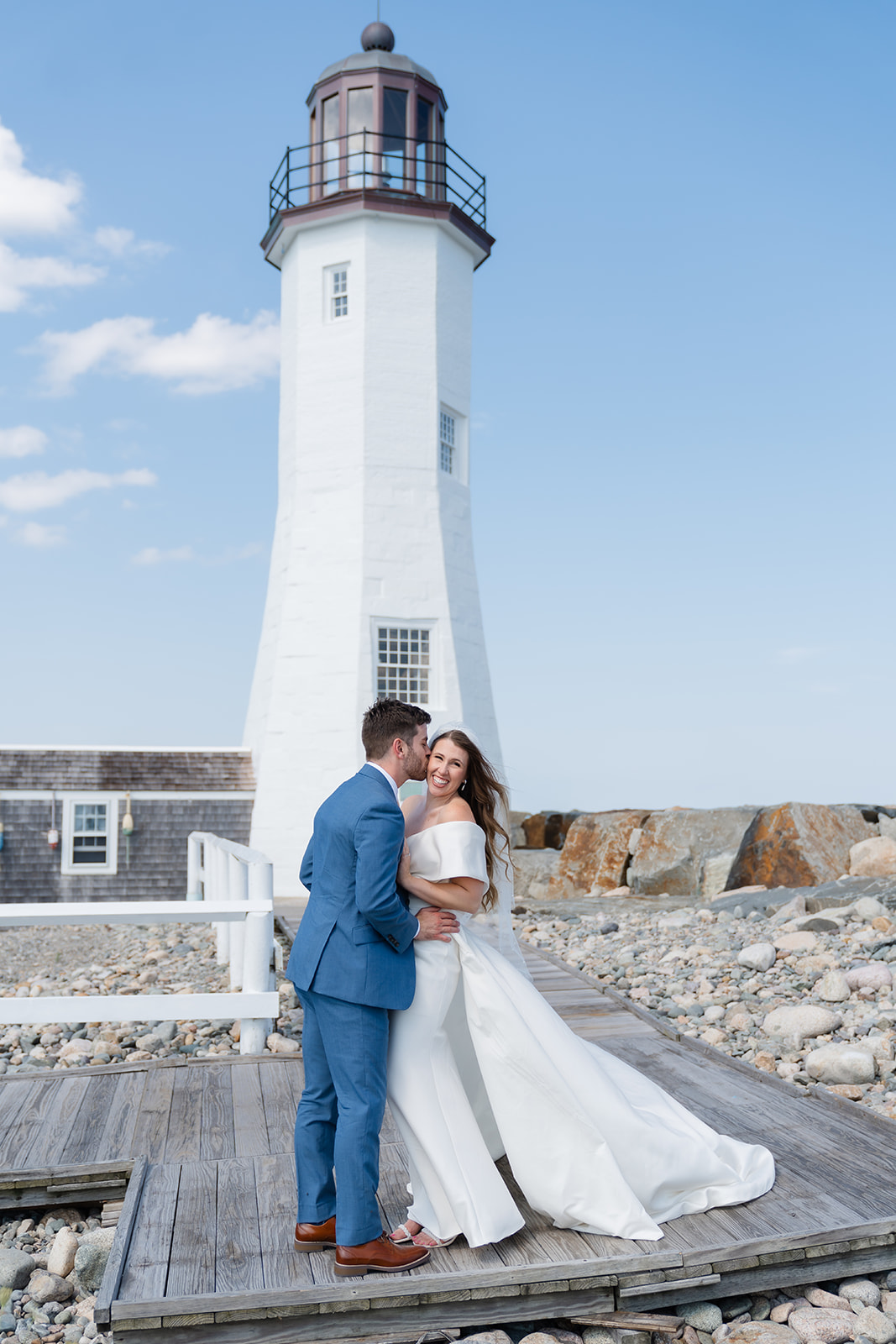 romantic wedding photo of the couple in front of a lighthouse