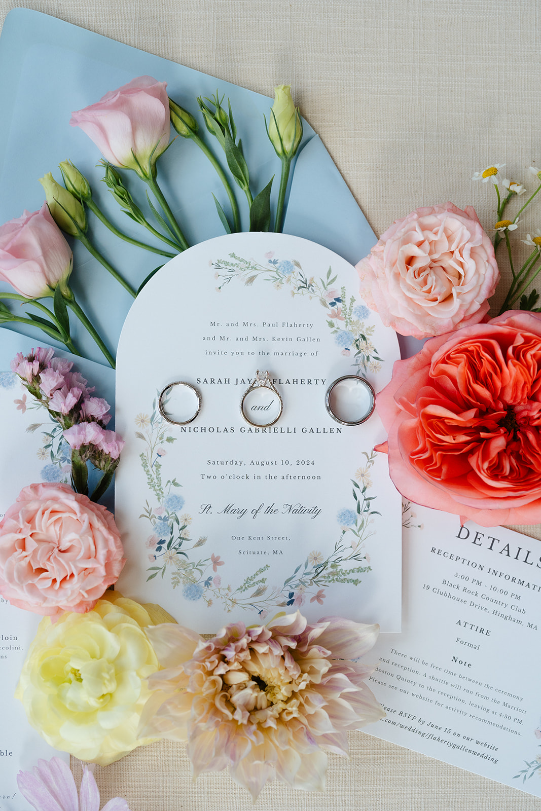 wedding invitations with wedding rings on top with flowers