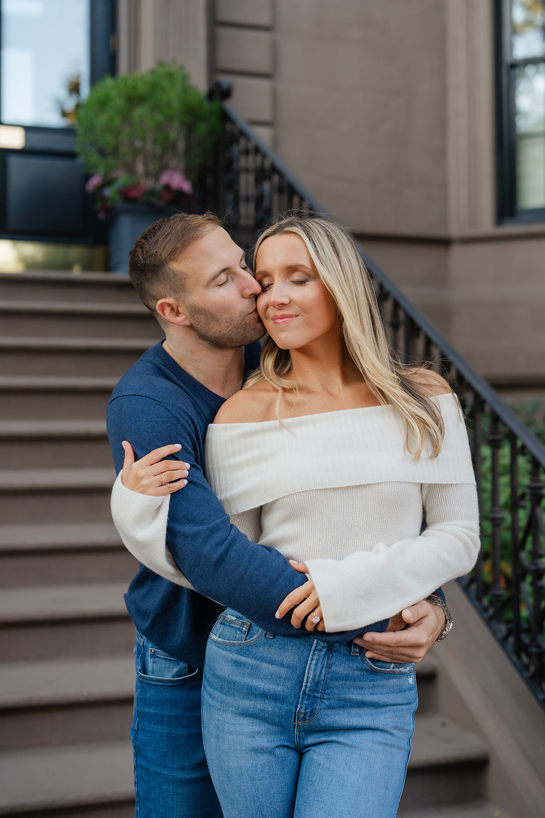 Couple embracing eachother as man kissing womans cheek during their Boston Public Garden Engagement photoshoot