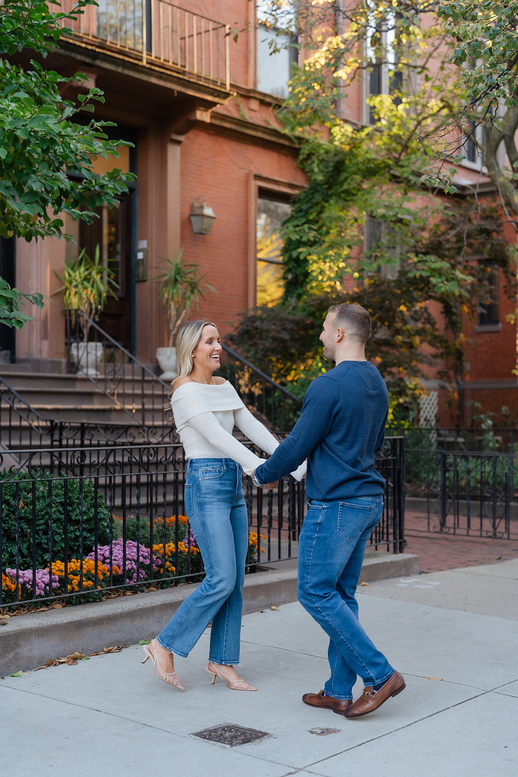 Couple dancing together near the Boston Public Garden, surrounded by lush greenery