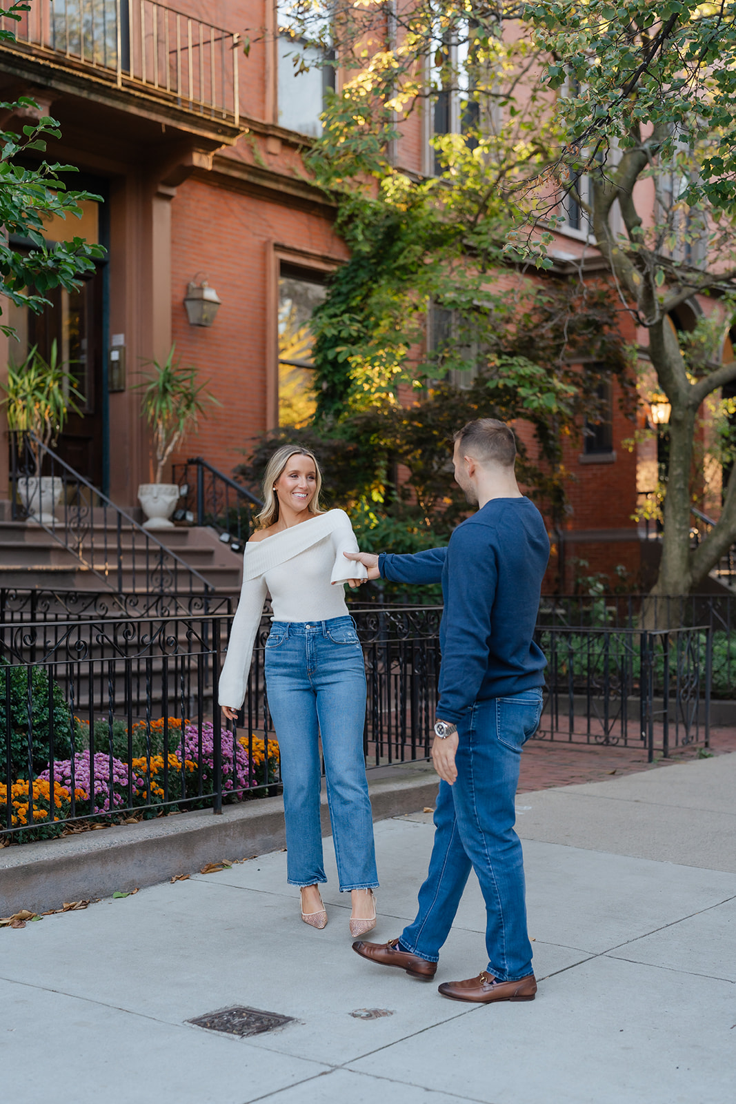 Couple dancing together near the Boston Public Garden, surrounded by lush greenery