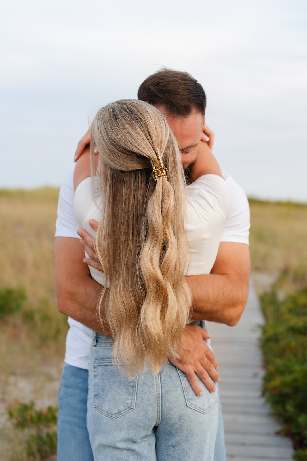 Intimate beach engagement shot of the couple hugging, showcasing their chemistry and the serene beach atmosphere.