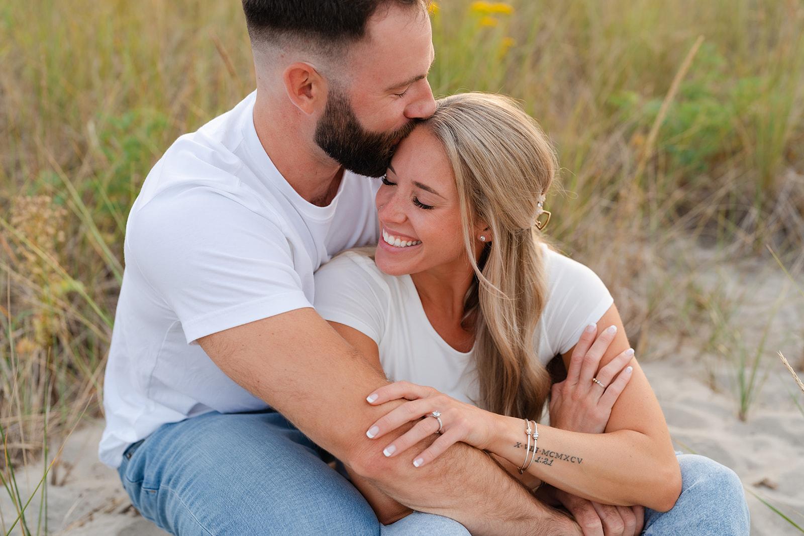 Close-up of a couple cuddling at the beach, highlighting the joy and natural connection between them, perfect for a beach engagement session.