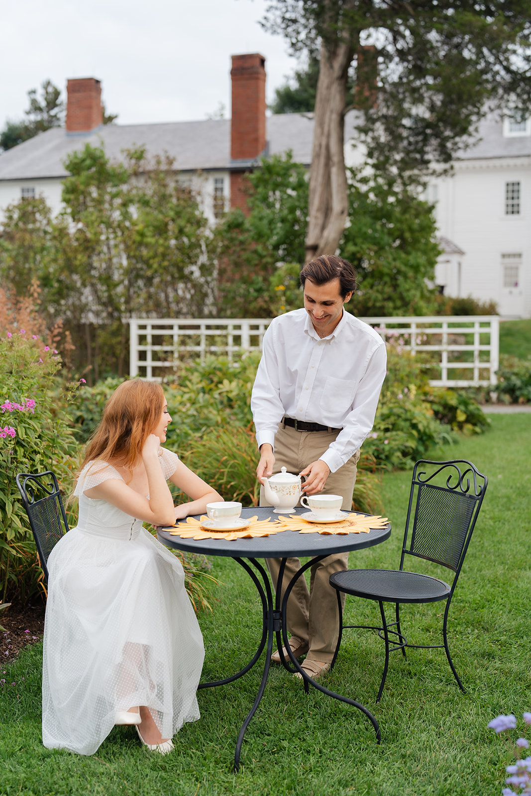 Couple enjoying a sunny moment at Stevens-Coolidge House & Gardens, creating unique engagement shoot ideas with a charming tea party setup.