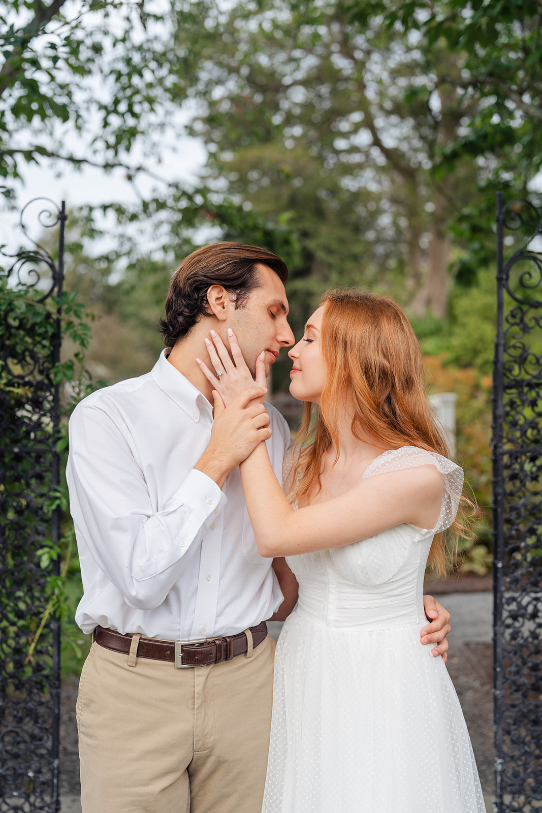 Romantic couple sharing a kiss in a garden, capturing candid moments with unique engagement shoot ideas at Stevens-Coolidge House & Gardens