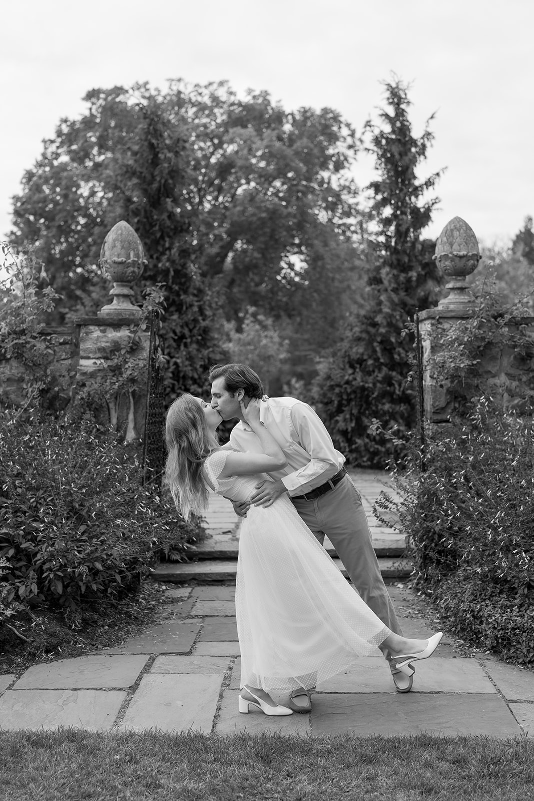 Romantic couple sharing a kiss in a garden, capturing candid moments with unique engagement shoot ideas at Stevens-Coolidge House & Gardens